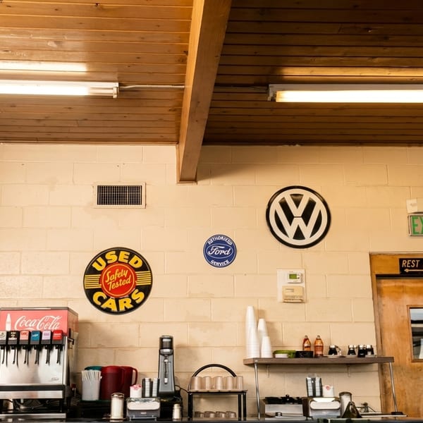A retro-themed restaurant counter with vintage car and scooter signs on a brick wall.